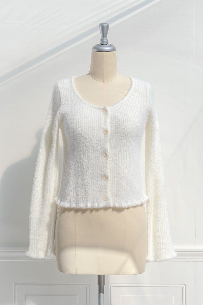 cream colored eyelash cardigan features a v-neckline, long sleeves, and a cropped length