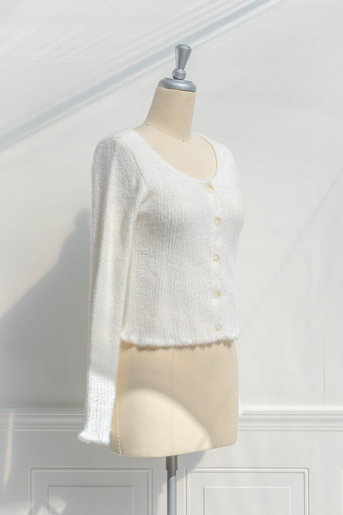 cream colored eyelash cardigan features a v-neckline, long sleeves, and a cropped length. side view. 