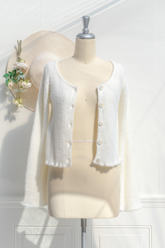 cream colored eyelash cardigan features a v-neckline, long sleeves, and a cropped length