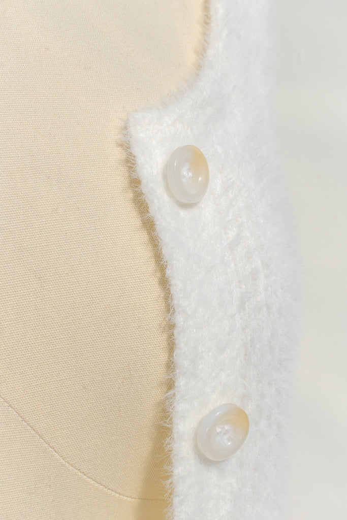 cream colored eyelash cardigan features a v-neckline, long sleeves, and a cropped length