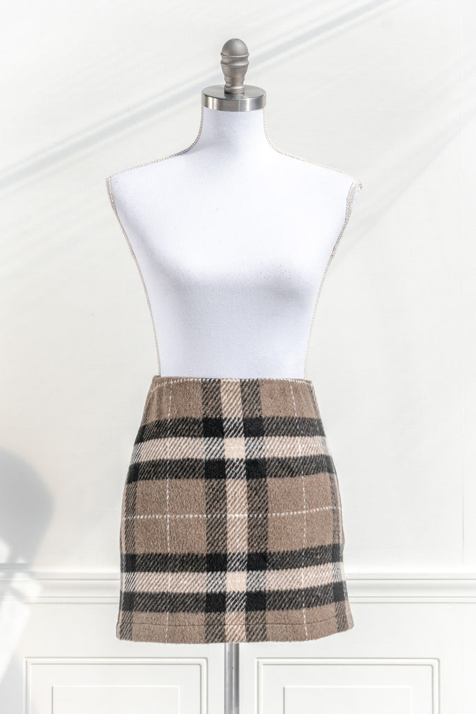 feminine clothing. a mini skirt features a soft tartan plaid print and a short length. Perfect with tights, a cardigan, and beret for a French-inspired collegiate look. front view. 