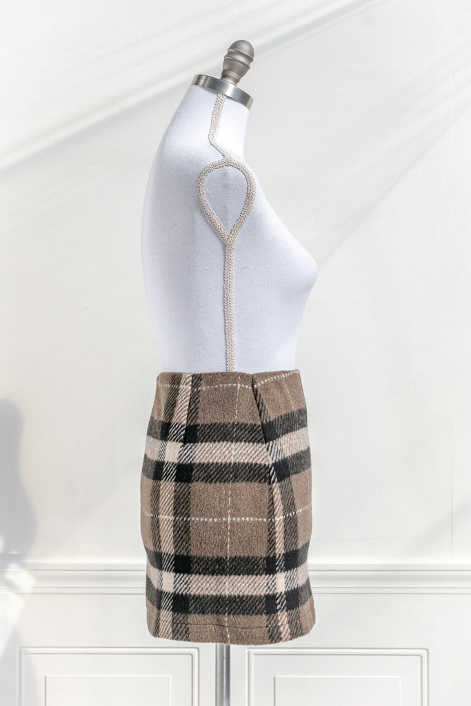 feminine clothing. a mini skirt features a soft tartan plaid print and a short length. Perfect with tights, a cardigan, and beret for a French-inspired collegiate look. side view. 