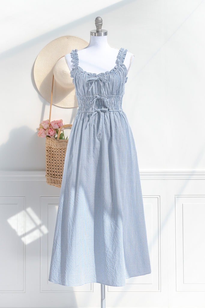 feminine and french inspired blue gingham dress. with ruffled straps, three bows, and pockets. perfect for cottagecore and french girl style ootd for spring. amantine. front view. 