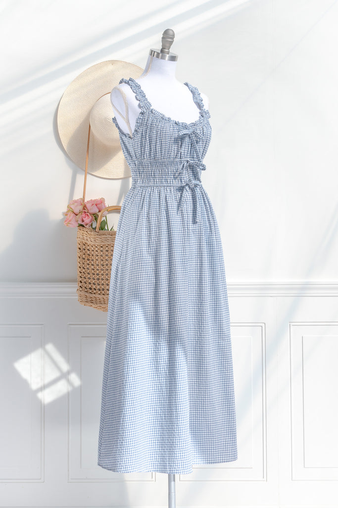 feminine and french inspired blue gingham dress. with ruffled straps, three bows, and pockets. perfect for cottagecore and french girl style ootd for spring. amantine. front view. 