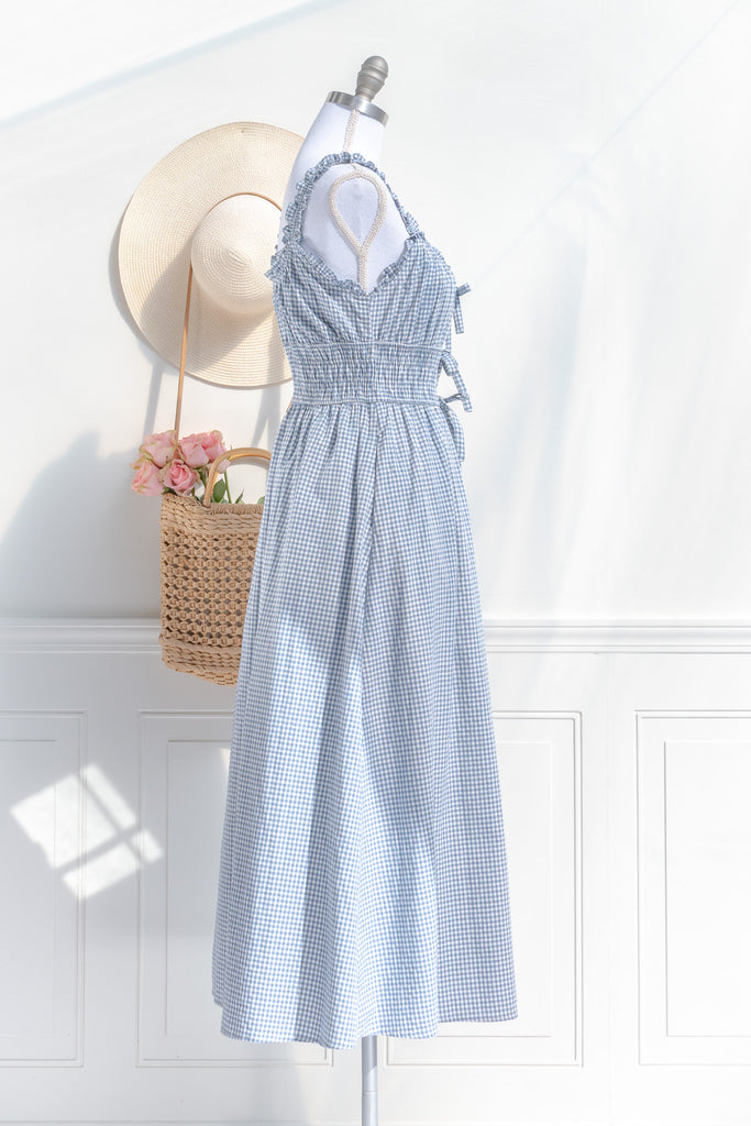 feminine and french inspired blue gingham dress. with ruffled straps, three bows, and pockets. perfect for cottagecore and french girl style ootd for spring. amantine. side view. 