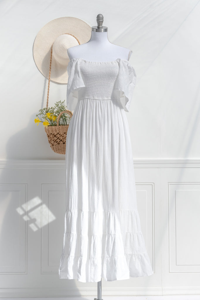 feminine clothing - a long white dress in a french and cottagecore style. featuring soft cotton fabric, bell sleeves, square neckline, and pockets. perfect for spring ootd. front view showing off shoulder style. 