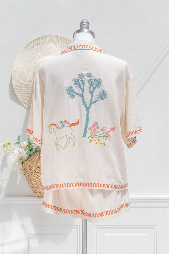 feminine clothing - a very unique summer set featuring a short sleeve button down shirt and shorts. In cream linen blend, it features very cute embroidery including a horse, and florals. A beautiful choice for your summer getaways. back view. amantine french style clothing. 