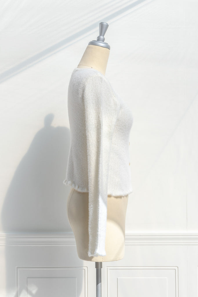 cream colored eyelash cardigan features a v-neckline, long sleeves, and a cropped length. side view. 