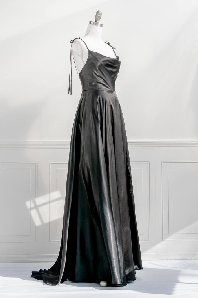 french elegant long black gown - made of a silky and shiny black fabric, with spaghetti straps, and a french feminine cowl neckline. features a side slit. quarter view - amantine.   