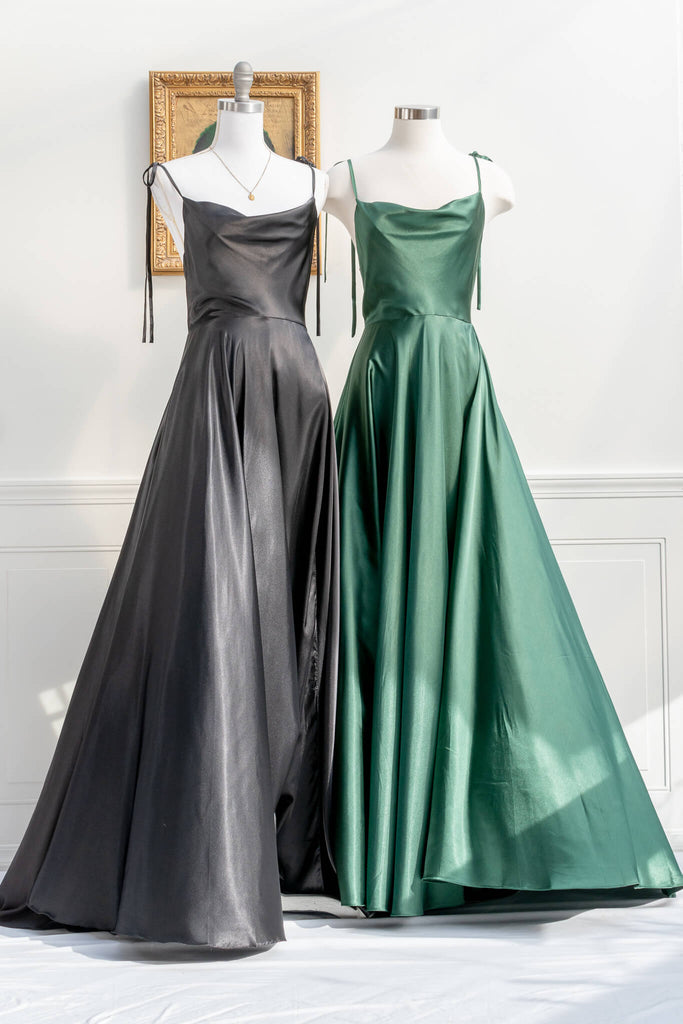 french elegant long black gown - made of a silky and shiny black fabric, with spaghetti straps, and a french feminine cowl neckline. features a side slit. next to green version view - amantine.   