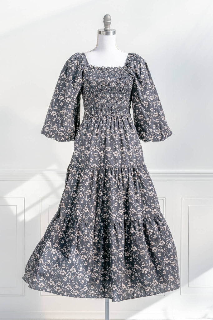 french dresses - dress with a smocked bodice, open-tie back, 3/4 length puffed sleeves, and a delicate vintage style taupe floral print on black. front view. Amantine. 