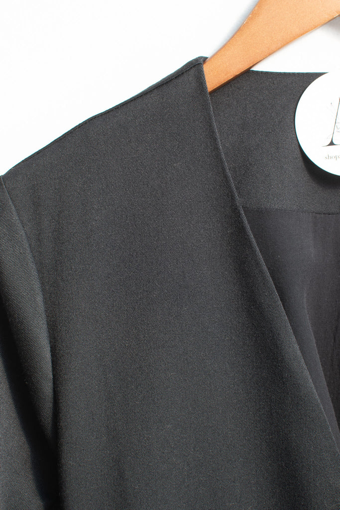 up close view of black fabric of elegant and feminine french style trench coat. 