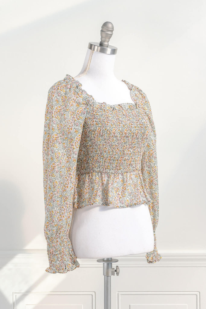 feminine tops - a cute tiny floral cottage core style blouse for women with a ruched body, square neckline, and long sleeves. quarter side view. Amantine.