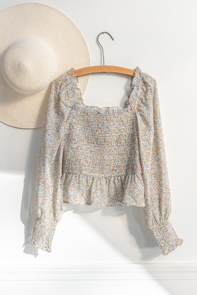 feminine tops - a cute tiny floral cottage core style blouse for women with a ruched body, square neckline, and long sleeves. on hanger view. Amantine.