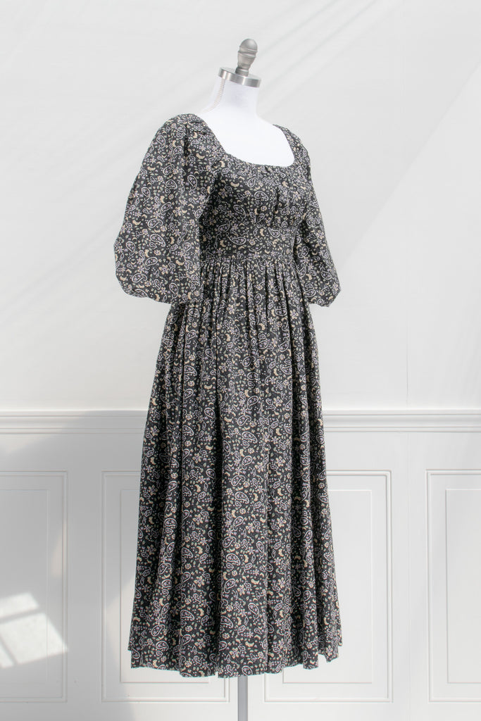 french style feminine dress - a puff sleeve square neckline full skirt floral dress. dark floral pattern. side view. 