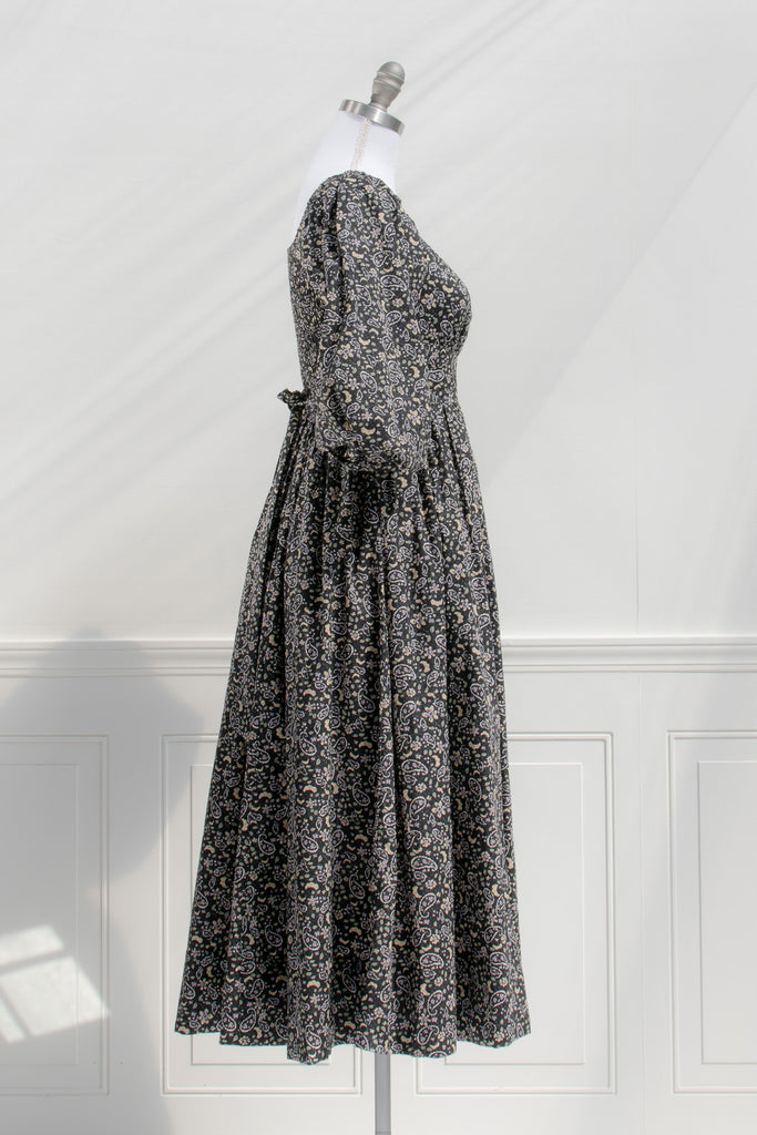 french style feminine dress - a puff sleeve square neckline full skirt floral dress. dark floral pattern. side view. 