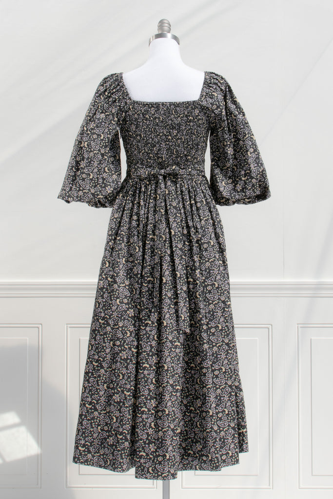 french style feminine dress - a puff sleeve square neckline full skirt floral dress. dark floral pattern. back view. 