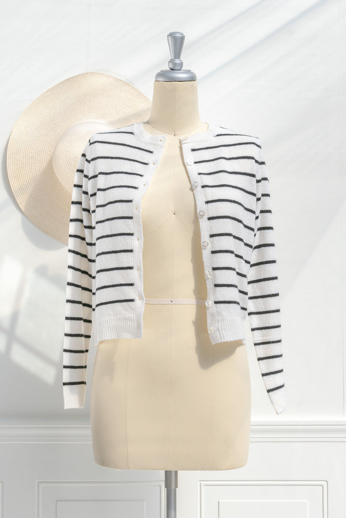 breton striped shirt - a classic light weight cardigan with black stripes against black stripes. button down long sleeve, crew neck. french girl style. front view showing unbuttoned cardi. amantine french fashion style. 