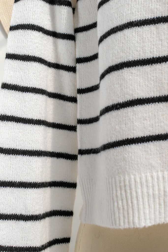 breton striped shirt - a classic light weight cardigan with black stripes against black stripes. button down long sleeve, crew neck. french girl style. up close fabric view. amantine french fashion style. 