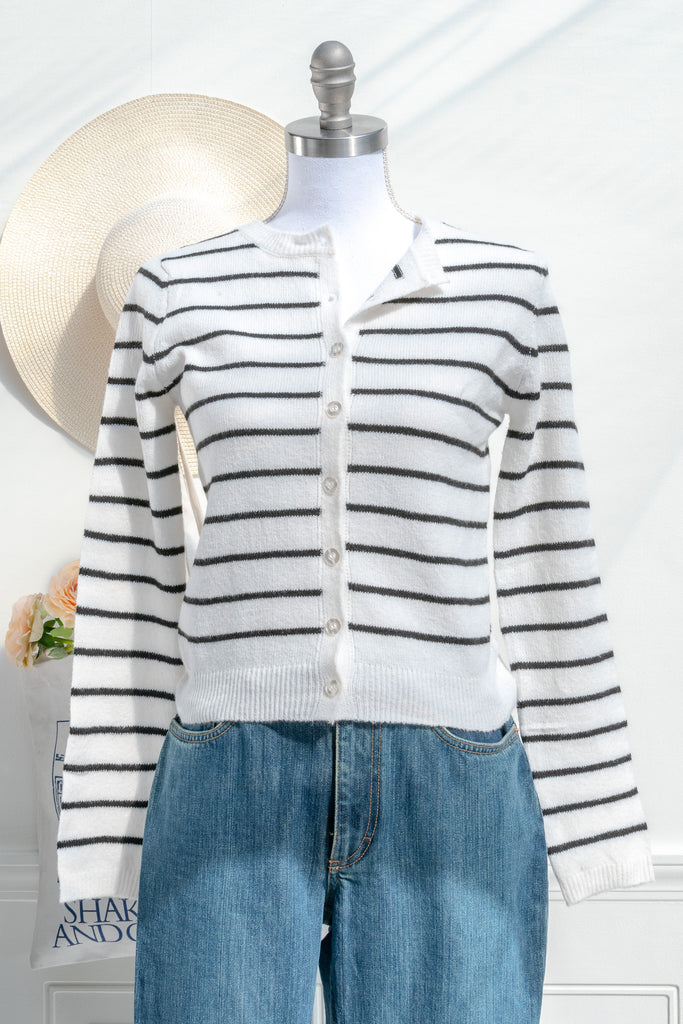 breton striped shirt - a classic light weight cardigan with black stripes against black stripes. button down long sleeve, crew neck. french girl style. front view styled with blue jeans. amantine french fashion style. 