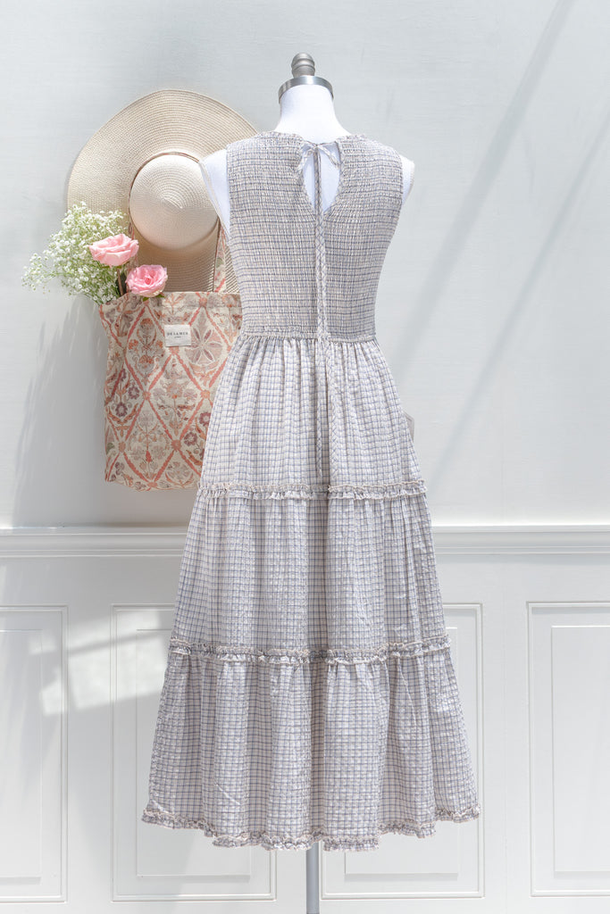 Checkered dress on a mannequin with a decorative box and flowers in the background
