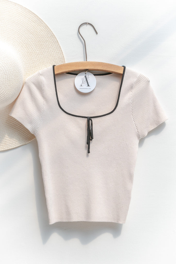 french tops - a cute knit blouse with square neckline, bow detail, and short sleeves. cropped top. front view. amantine. 