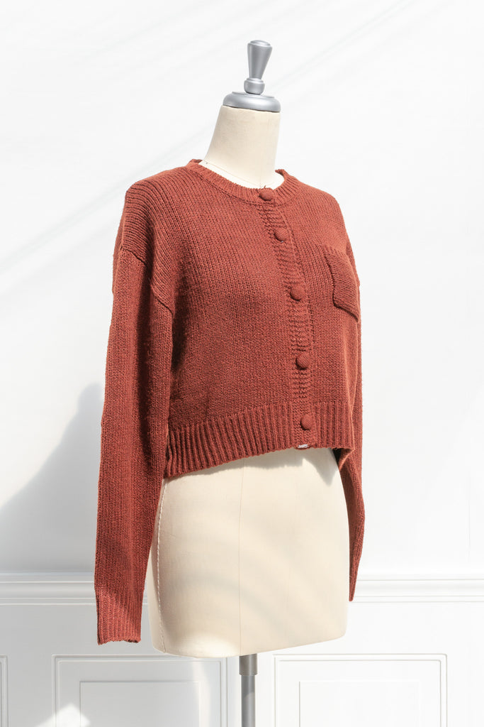 french tops. feminine cottagecore style. a cute rust color button down cardigan. 3/4 side view. amantine. 