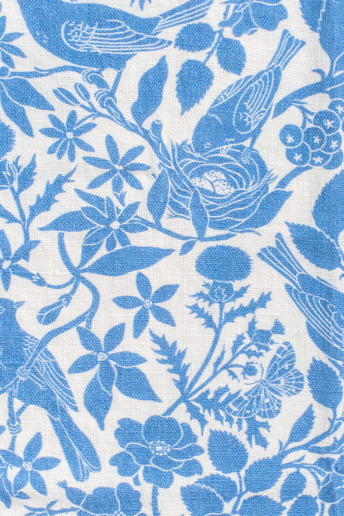 a french kitchen essential - a linen tea towel with a blue bird print motif. the perfect gift for the francophile in your life. Up close view of bird and bird nest print. 