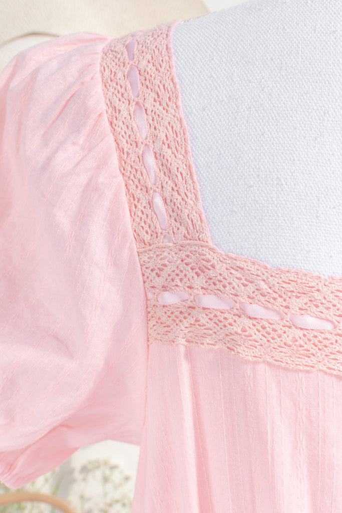 Close-up of pink dress fabric highlighting intricate lace patterns and soft, breathable material. amantine dresses. 