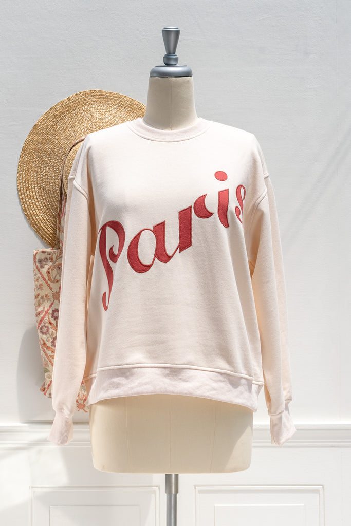 Beige sweatshirt with 'Paris' text on a mannequin against a white background