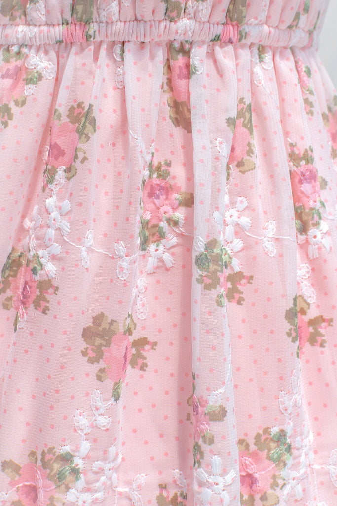 up close view of fabric showing little pink, white, and light green floral detail. 