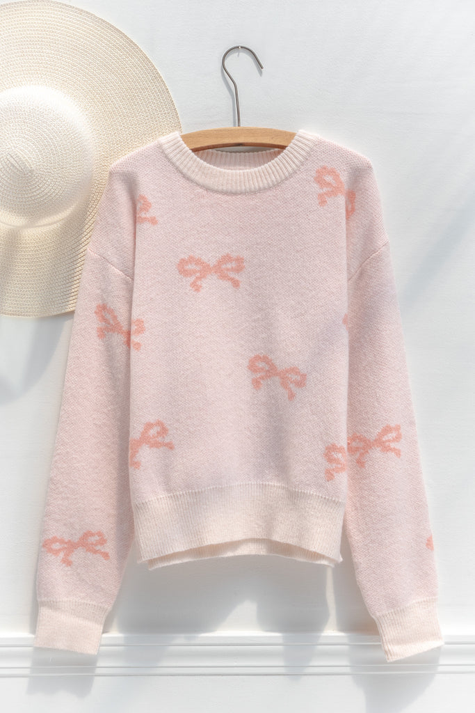 cute pink sweater - crew neck, with bow detail print. cute pink outfits. hanger view. 