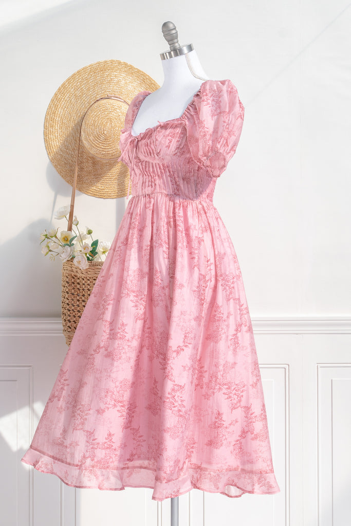 Pink Clothes -a beautiful floral pink dress with puff short sleeves, sweetheart neckline, ruched midriff, and a midi length. Perfect for spring time. 3/4 side View. Amantine pink dresses.  