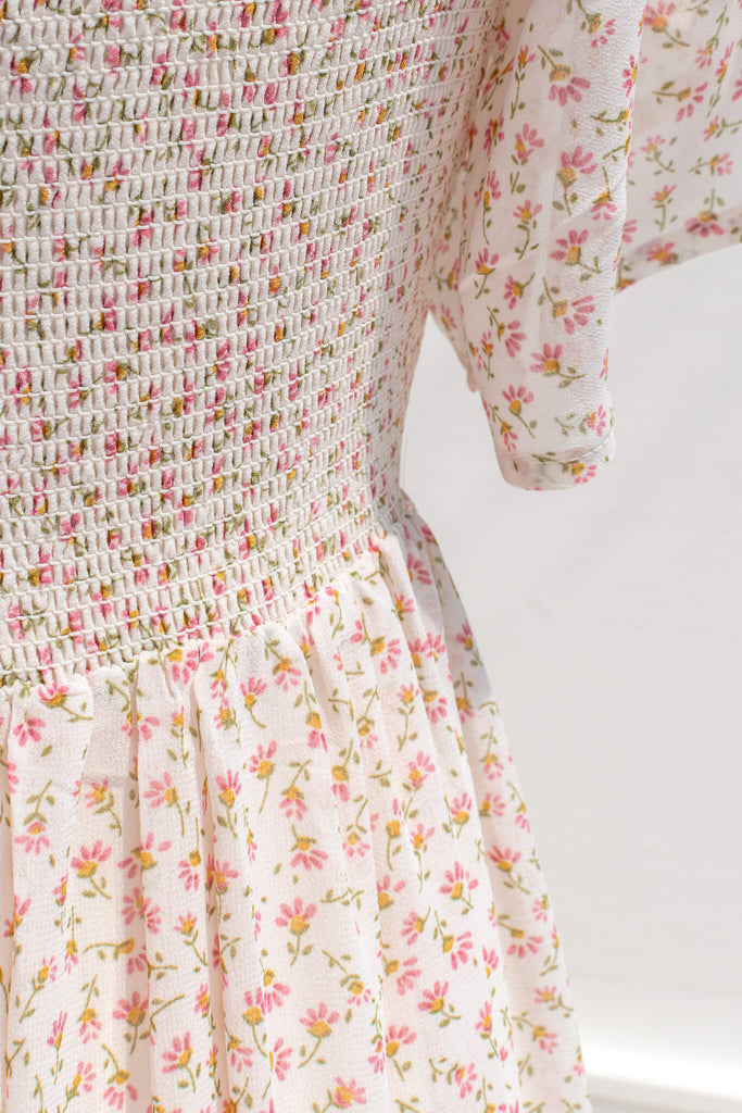 pink clothing - a pink floral dress in chiffon fabric. picture showing smocked bodice and bell sleeve view. 