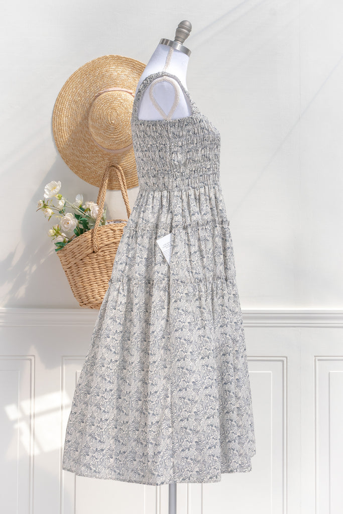 pretty dresses for spring. a romantic, vintage-inspired piece featuring a delicate floral print on a soft, blue and white floral 100% cotton. side view. amantine. 