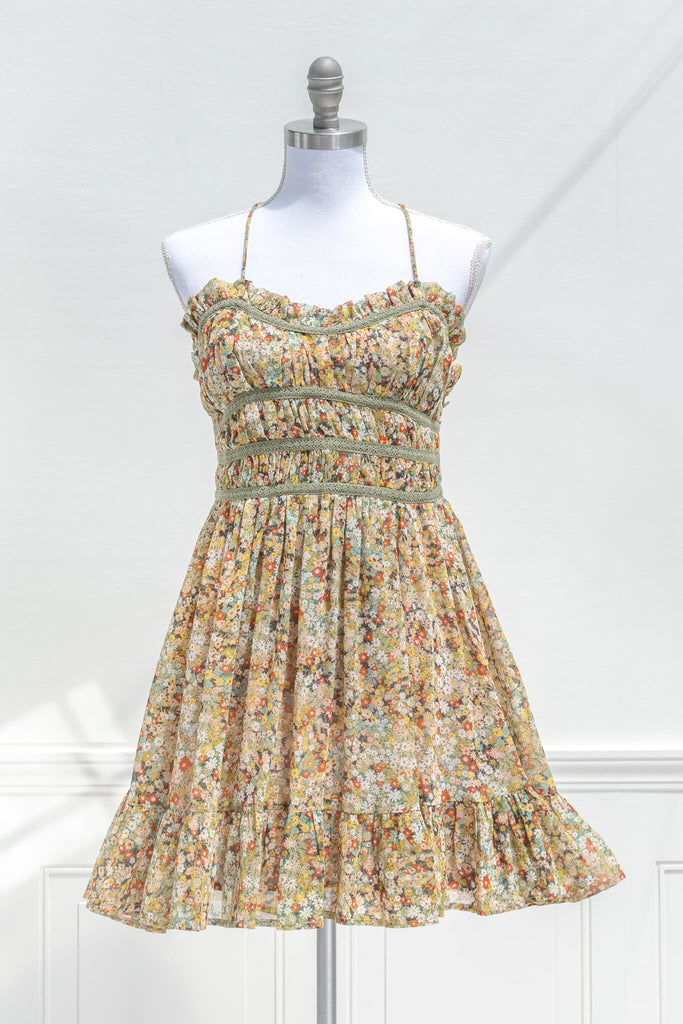 vintage style sun dresses - a mustard and green floral mini dress with straps. front view. 