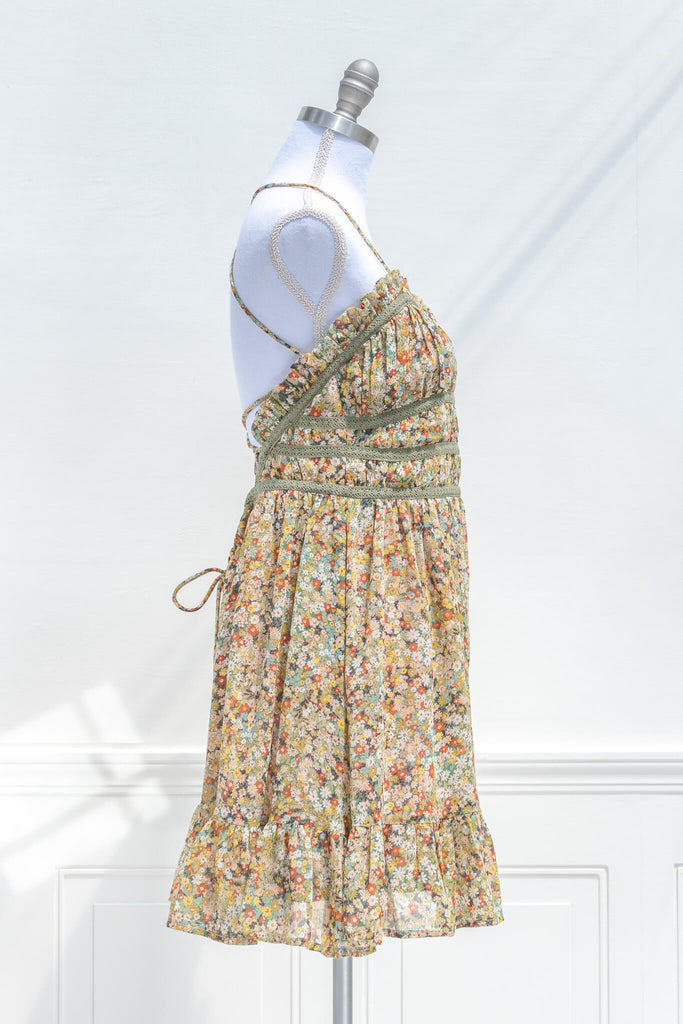 vintage style sun dresses - a mustard and green floral mini dress with straps. side view. 