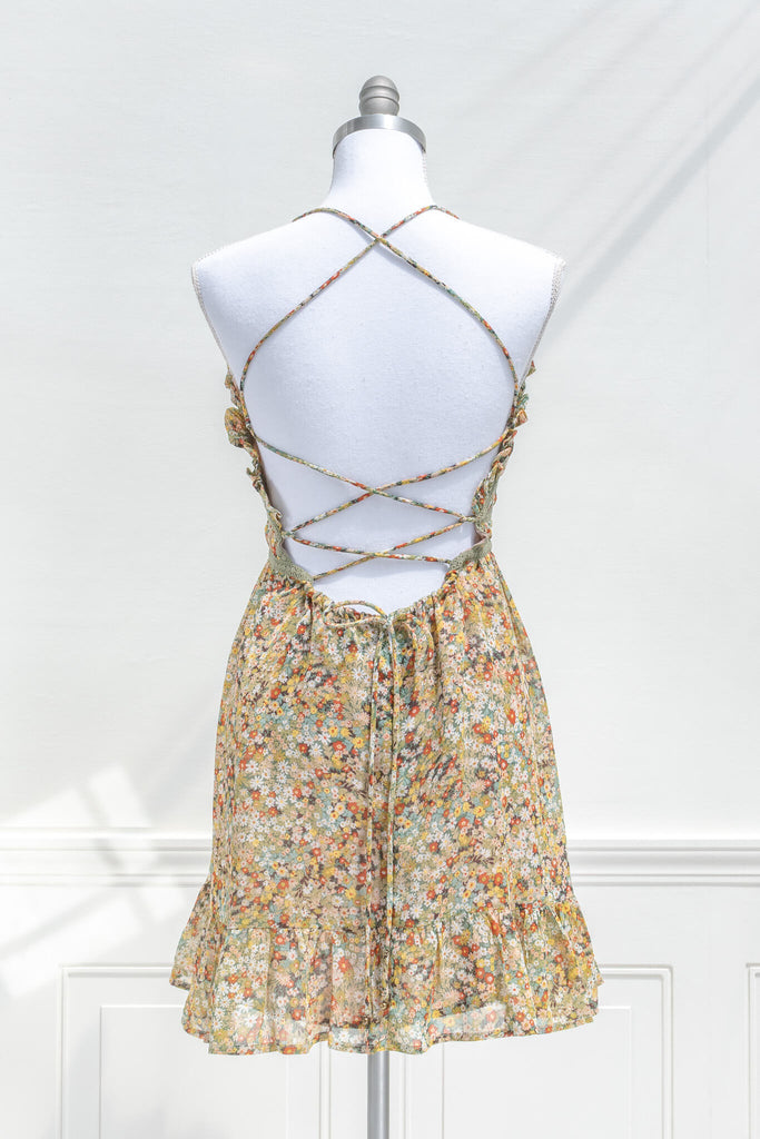 vintage style sun dresses - a mustard and green floral mini dress with straps. back view. 