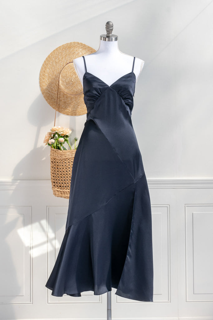 Beautiful wedding guest and formal dress in navy blue. French style feminine and romantic dress with straps, slit, and a bow. Front view. Amantine dresses. 