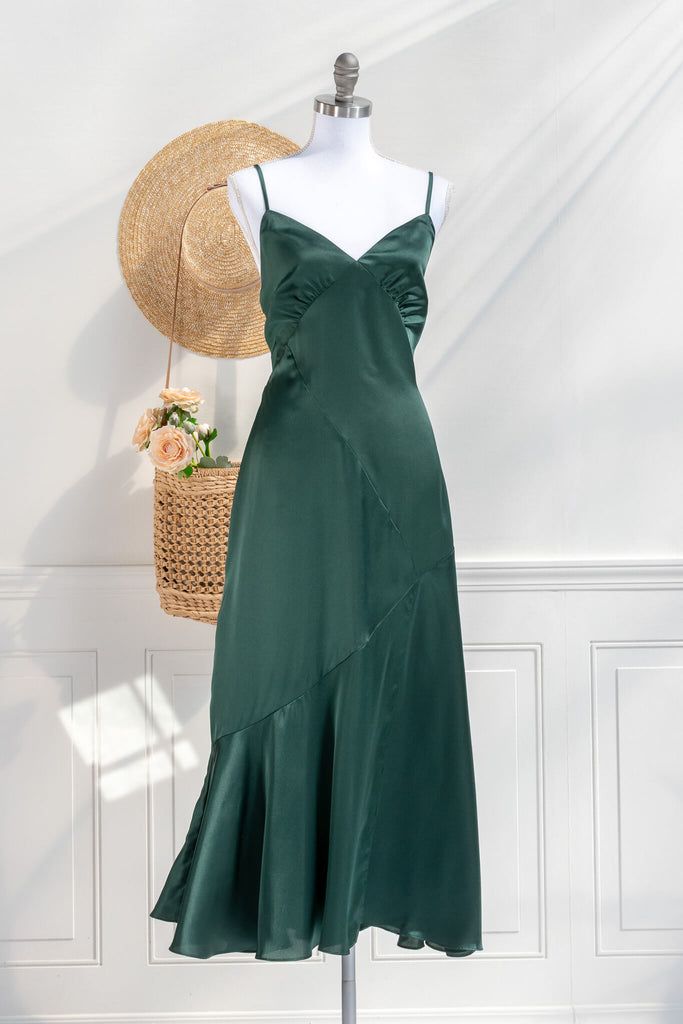 Beautiful wedding guest and formal dress in emerald green. French style feminine and romantic dress with straps, slit, and a bow. Front view. Amantine dresses. 