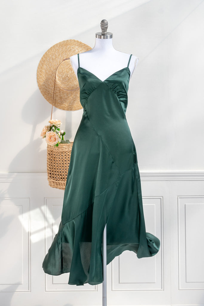 Beautiful wedding guest and formal dress in emerald green. French style feminine and romantic dress with straps, slit, and a bow. Front view. Amantine dresses. 