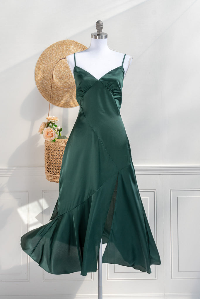 Beautiful wedding guest and formal dress in emerald green. French style feminine and romantic dress with straps, slit, and a bow. Front view. Amantine dresses. 