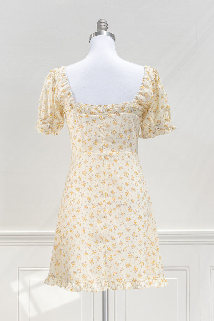 cottagecore dresses for spring - a mini yellow floral dress with a front bow, sweet heart neckline, and short sleeves. back view. amantine. 