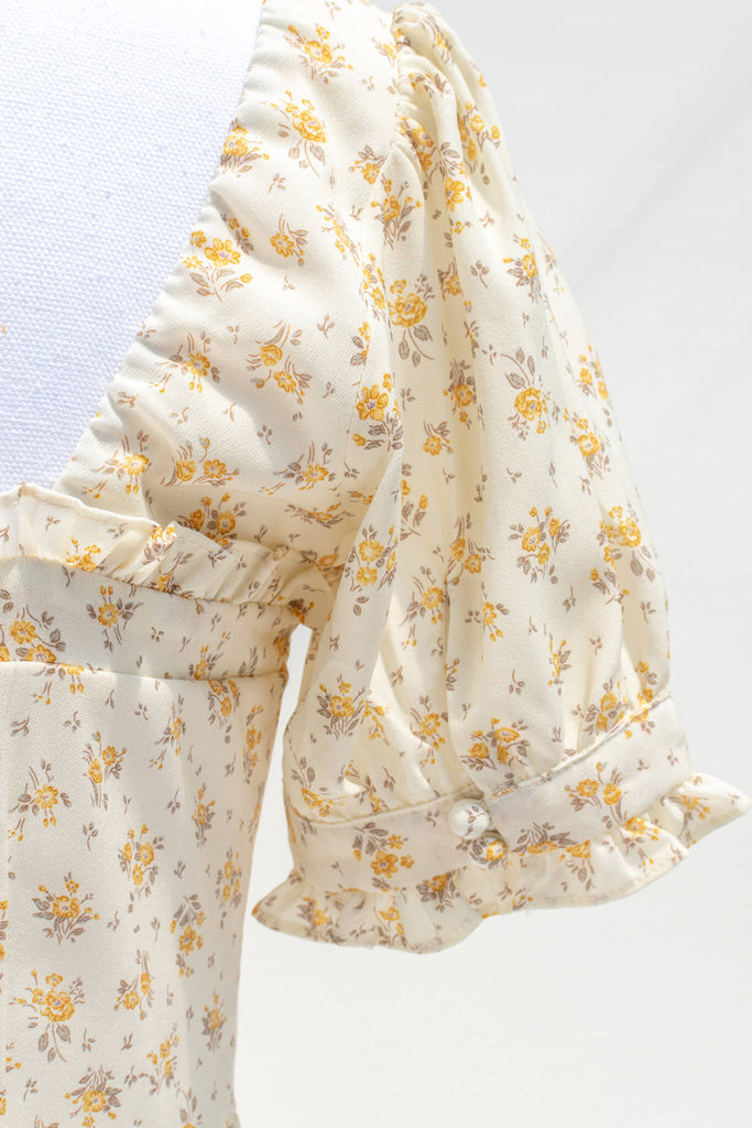 up close view showing yellow floral detail with half inch flower print. 