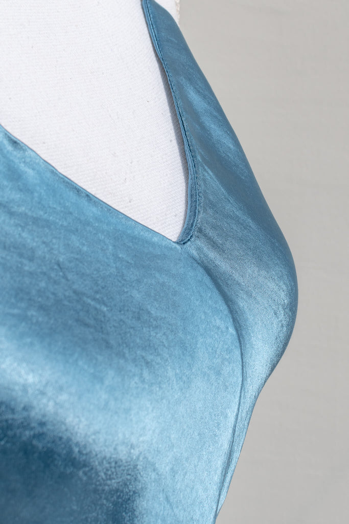 french slip dress - light blue slip dress with adjustable shoulder straps, v neckline, and satin quality fabric, midi length - amantine - french style - fabric detail up close shows shimmering satin fabric